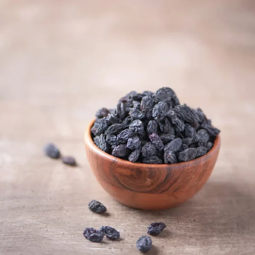 black-raisins-in-wooden-bowl-on-wood-textured-back-2021-08-27-14-33-27-utc-scaled